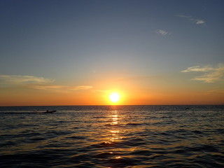 ボルネオの夕日の海を走るボート