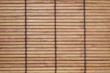 Texture of a wooden bamboo tablecloth. Kitchen interior. Stalks of a bamboo section fixed among themselves by a thread.