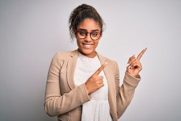 Beautiful african american businesswoman wearing jacket and glasses over white background smiling and looking at the camera pointing with two hands and fingers to the side.