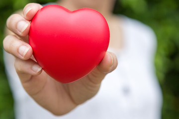 Selective focus of A woman with a heart shaped ball in her hand  on blurred background