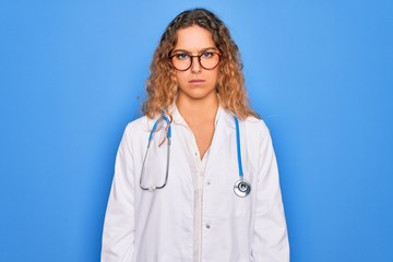 Young beautiful blonde doctor woman with blue eyes wearing coat and stethoscope skeptic and nervous, frowning upset because of problem. Negative person.