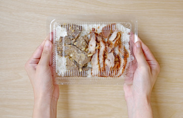 Hands holding Food in plastic box.