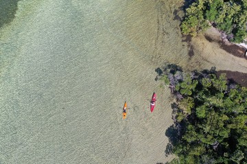 Key Biscayne, Florida - May 5, 2020 - Young couple enjoys afternoon of kayaking on calm, clear...