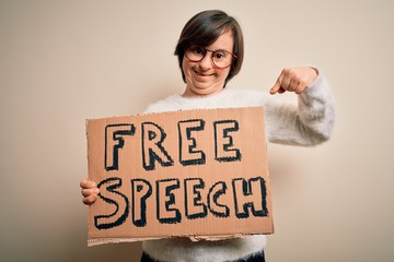 Young down syndrome woman holding protest banner of free speech for communication rights very happy...