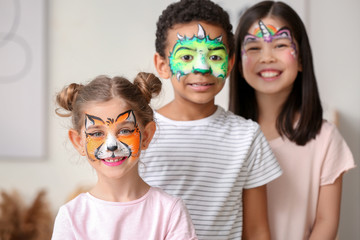 Funny little children with face painting at home