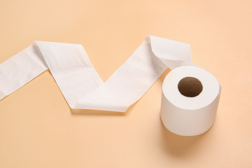 Roll of toilet paper on color background