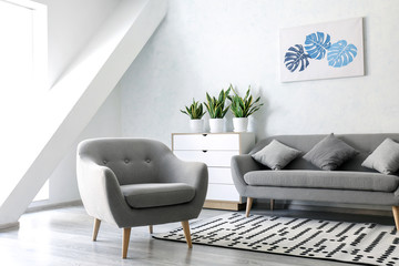 Interior of modern room with comfortable armchair and sofa