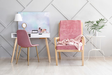 Interior of modern room with comfortable armchair and dressing table