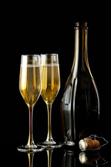 Glasses and bottle of champagne on dark background