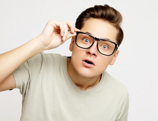 young man with emotions on his face a grey background