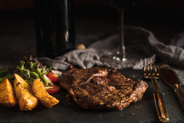 food background of beef rib eye steak with black pepper sauce served with baked potato and...