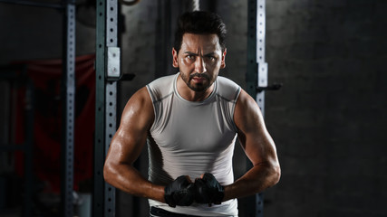 Fototapeta na wymiar sport portrait of caucasian athletics strong bodybuilder man posing show his muscle in gym in dark tone