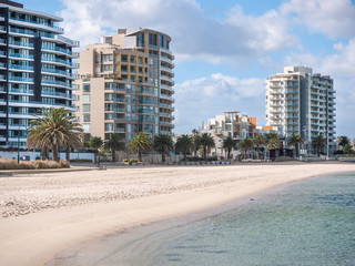 Waterfront apartment buildings in Port Melbourne. Residential buildings facing a sandy beach with...