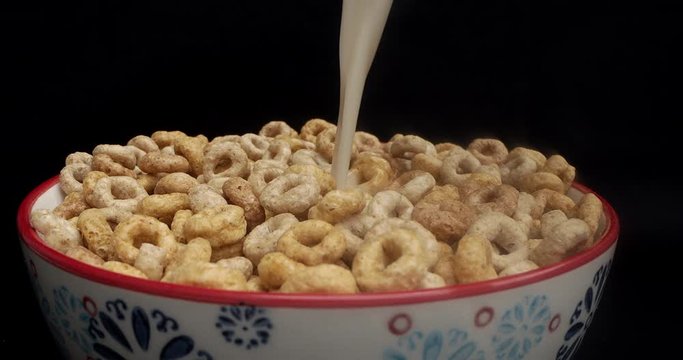 Poring oat milk on Cheerios whole grain cereals.