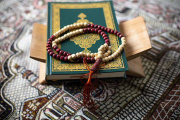 Quran - holy book of Muslims religion, Concept: open book holy prayers for god,
 Friday In the month of Ramadan  religion Islamic worshiping faith and learn koran and rosary put on wooden  boards 