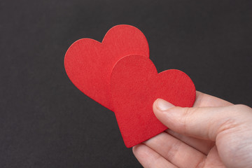 Hand holding red hearts . Valentine concept and promise of love.