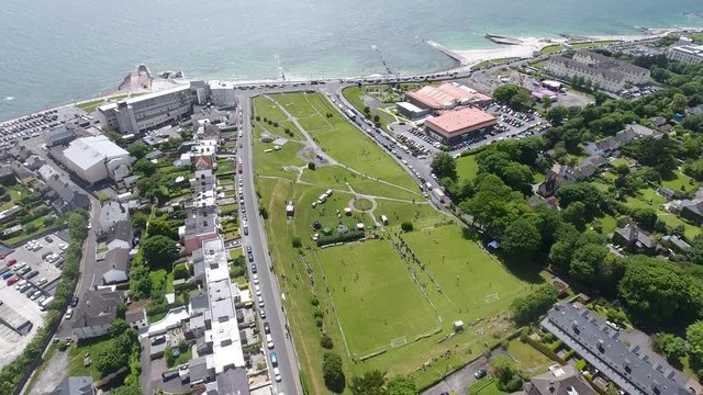 Ascending drone shot above Salthill Park in Galway with the sea and beach  in the background.