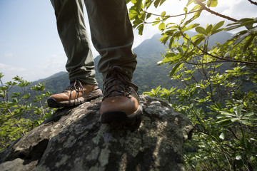 Successful hiker enjoy the view on mountain top cliff edge