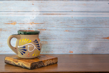 cup of mexican coffee on table with vintage planks background