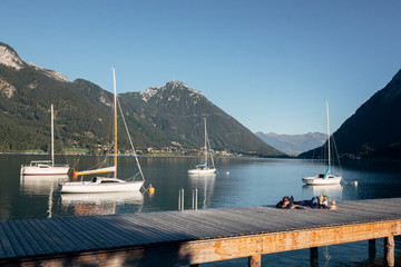 People relaxing on a pier by Achensee, Tirol, Austria