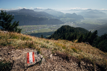 Trail marker in the Austrian alps with the Inntal valley visible in the distance