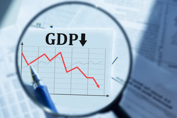 Fall in GDP. A person looks through a magnifying glass at changes in GDP indicators. Economic...