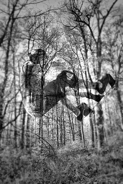 Double Exposure Of Person Skateboarding With Trees In Forest