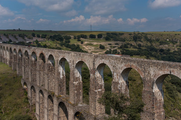 Obraz premium Aqueduct Los Arcos Tepotzotlán, Mexico October 07 2018 A wide arched passageway in the back of the complex leads to the extensive gardens area of more than 3 hectares, filled with gardens,