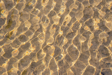 Klares Wasser einer sprudelnden Quelle mit Wasserpflanzen und klarer Bach mit seidigen Wellen für Entspannung und Meditation zeigen schöne Reflexionen auf der Wasseroberfläche mit unberührter Natur