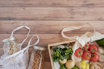 zero waste lifestyle .cotton net bag with fresh vegetables on wooden table flat lay.plastic free...