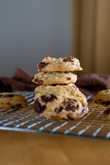 Homemade baked chocolate chip soft cookies cooling on a cooling rack. On a wooden background. Natural light.