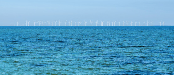 Wind turbine generating electricity on blue sea. Wind-driven generator in Baltic sea, Oresund strait