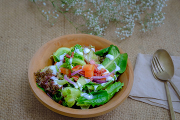 Fresh salad bowl on brown cloth background, vegetable eating, diet food