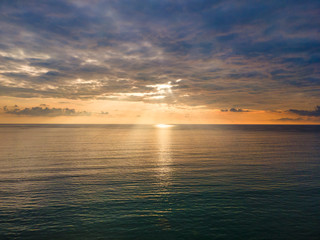 Fototapeta premium Aerial Drone view sunset over the sea with cloud and sun light with copy space.
