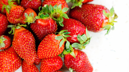 Freshly picked strawberries from the home garden. Natural organic food production. Heap of summer red berries. Homegrown, gardening and agriculture concept. Close up. Soft focus