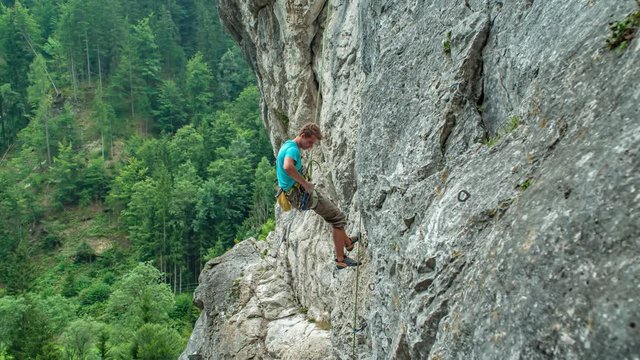 Caucasian adult man climbing rocky mountain Burjakove Peci, Slovenia