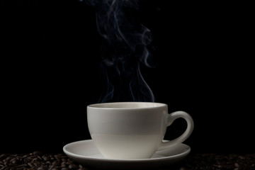 Hot black coffee with white smoke motion blur up on the air on black background
