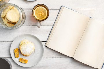 Lemon butter biscuits with lemon tea and an open book.