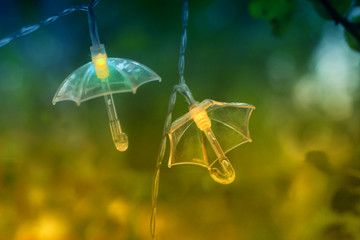 Hanging garland in form of umbrellas. Luminous garland of umbrellas.  Magical park lighting.