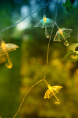 Hanging garland in form of umbrellas. Luminous garland of umbrellas.  Magical park lighting.