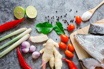 Top viwe,red onions, lemon, lemongrass, chilies,galangal,.salt,tomato,kaffir lime leaf and .fish on a stone background with copy space for your text. healthy food for people.