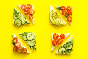 vegan avocado sandwiches on yellow desk top view pattern