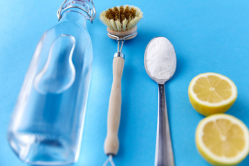 natural cleaning stuff, sustainability and eco living concept - lemon halves, washing soda, bottle...