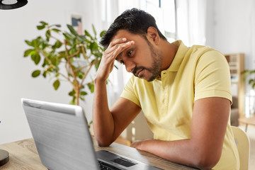 technology, remote job and business concept - stressed indian man with laptop computer working at...