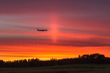 Fototapeta na wymiar Airplane flying against the sunset