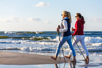 Nordic walking - two women working out on beach