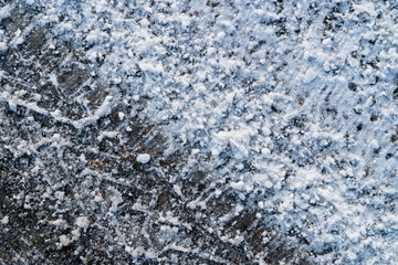 Track from car tire on asphalt covered with snow