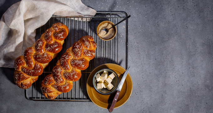 Breakfast with beautiful homemade bread and butter. Main ingredients of bread are eggs, white flour, water, sugar, salt  and yeast. Decorated  with sesame and poppy seeds. Copy space.