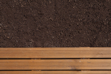 Brown garden soil and wooden path background. Gradening season concept
