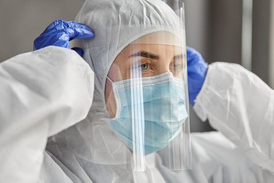 health safety, medicine and pandemic concept - close up of female doctor or scientist in protective wear, medical mask, face shield and gloves for protection from virus disease